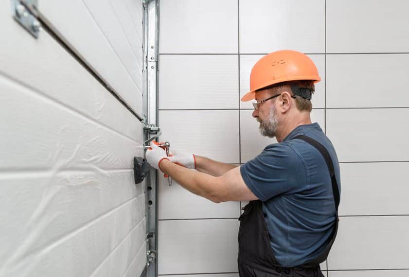 worker performing insulated garage door installation chicagoland